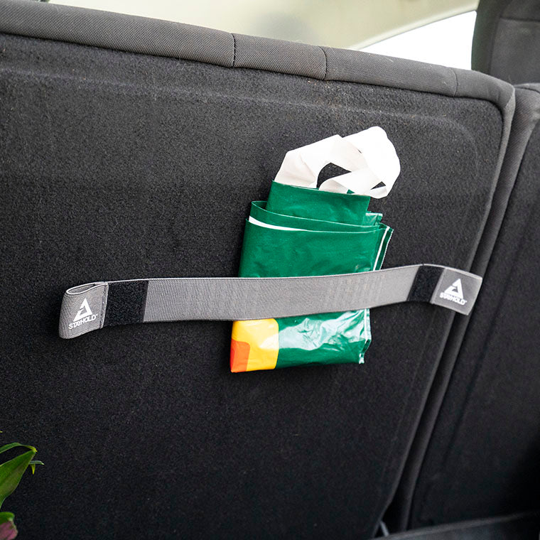 stayhold elasticated combi strap being used to hold reusable shopping bag on the side wall of the car in the trunk